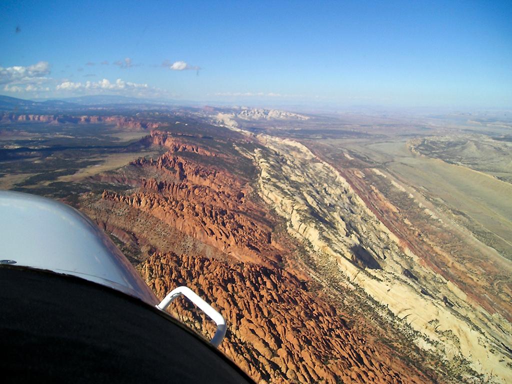 An aerial view of a line of beige and red rock constituting the Waterpocket Fold geologic structure at Capitol Reef National Park