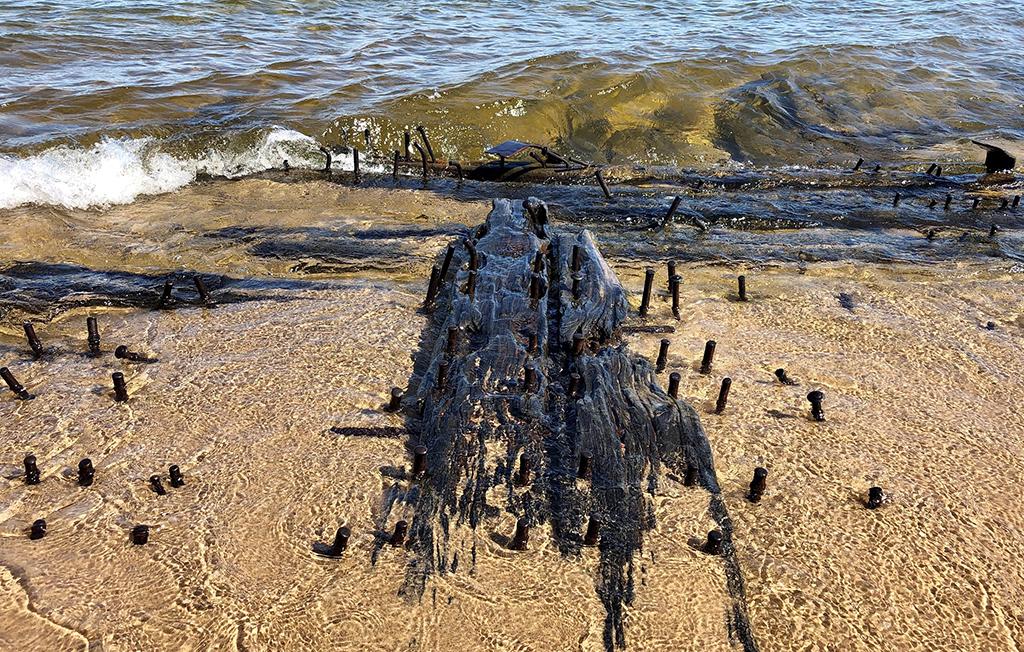 The remains of a shipwreck laying on the sandy beach of Lake Superior at Pictured Rocks National Lakeshore