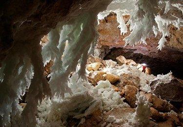 A caver views massive gypsum chandeliers in the Chandelier Ballroom at Lechuguilla Cave. Credit: Max Wisshak, NPS