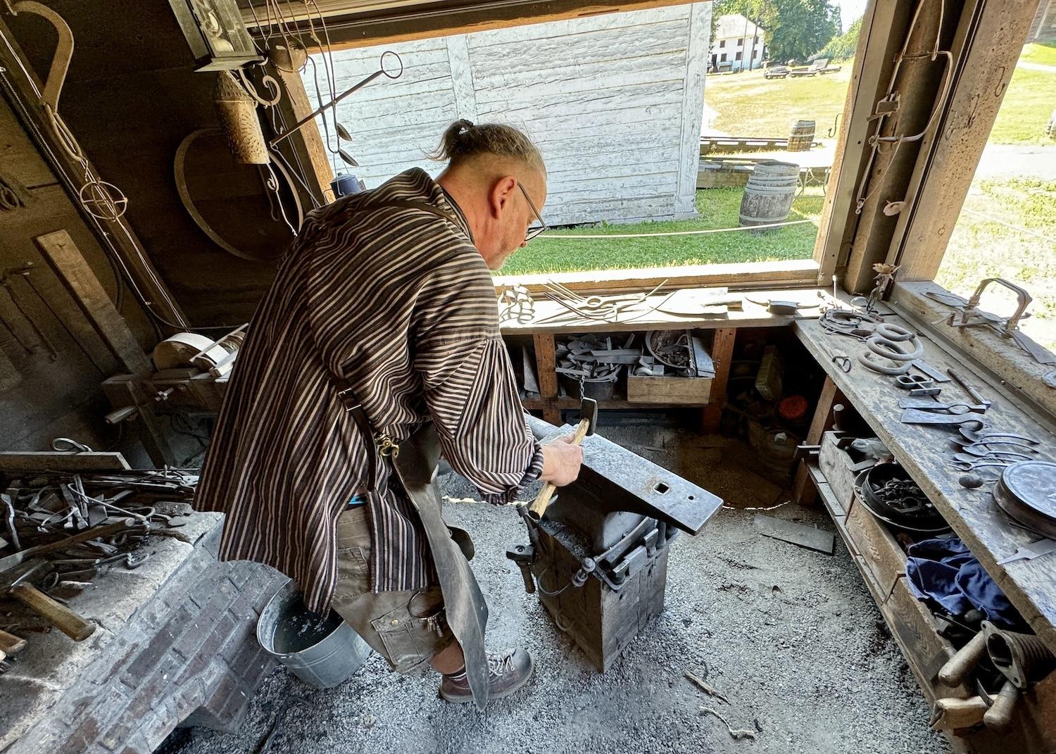 Blacksmith Danny Cram works at an anvil at Fort Langley.