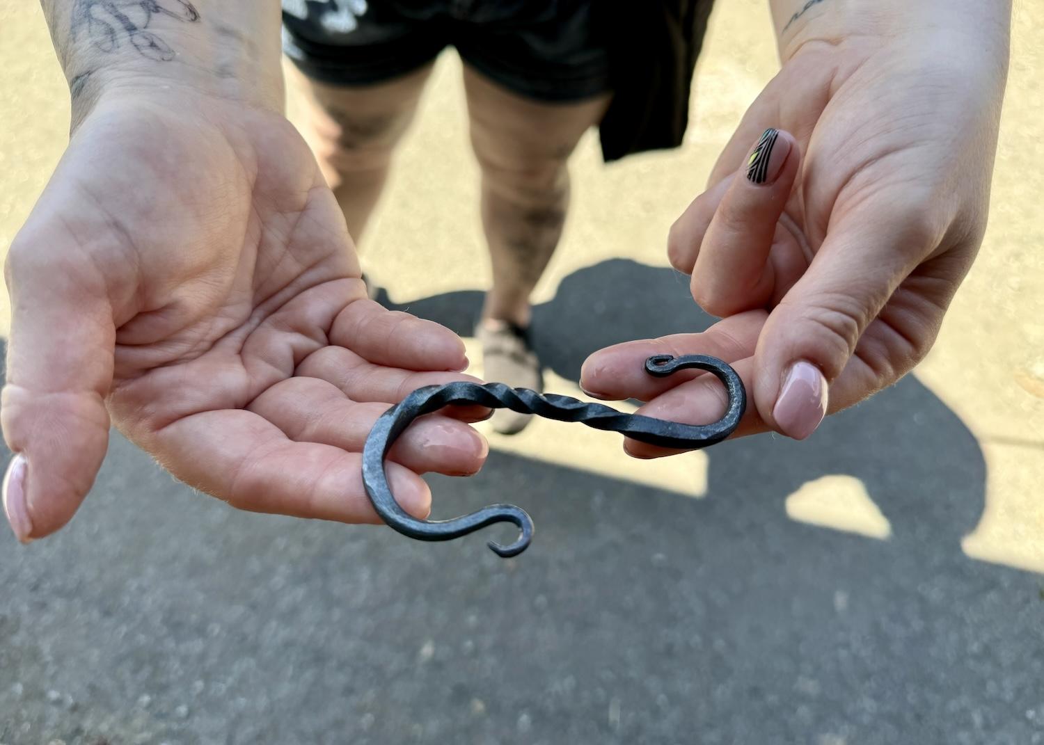 A Fort Langley visitor cradles an asymmetrical hook made for her by blacksmith Danny Cram.