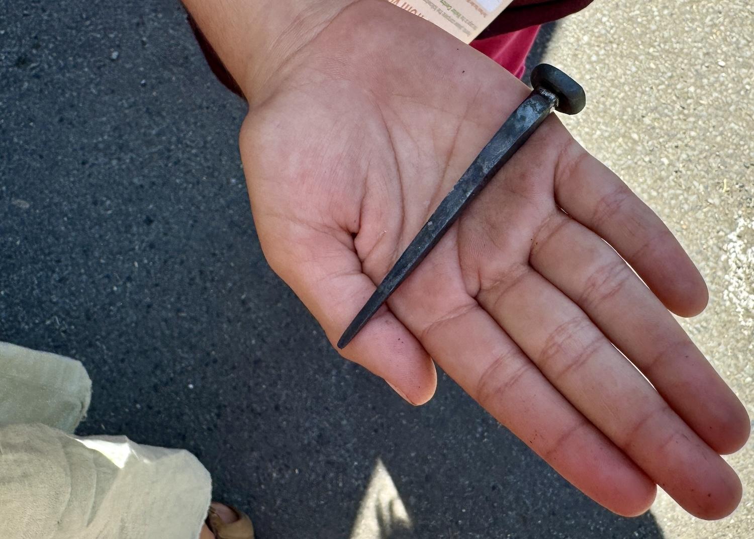 A young visitor to Fort Langley National Historic Site shows off the nail that blacksmith Danny Cram made and gave to her.