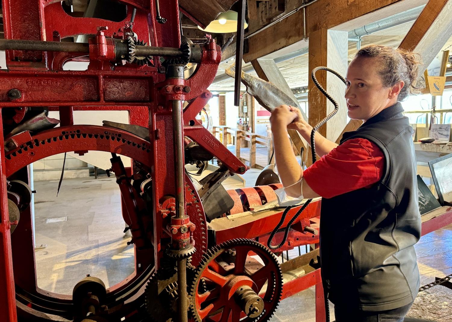 Jamie Lee, head interpreter at Gulf of Georgia Cannery National Historic Site, demonstrates how the "Iron Butcher" worked and replaced human workers.