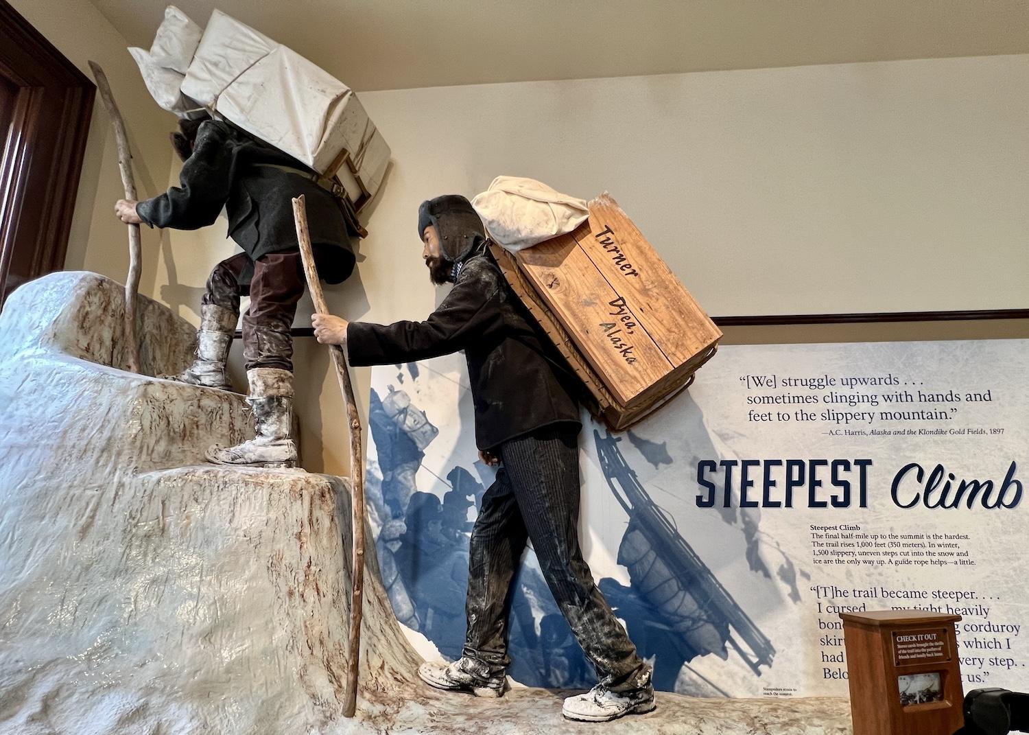 In the NPS visitor center museum in Skagway, an exhibit conveys how gold rush stampeders had to carry heavy loads through extreme Alaska weather.