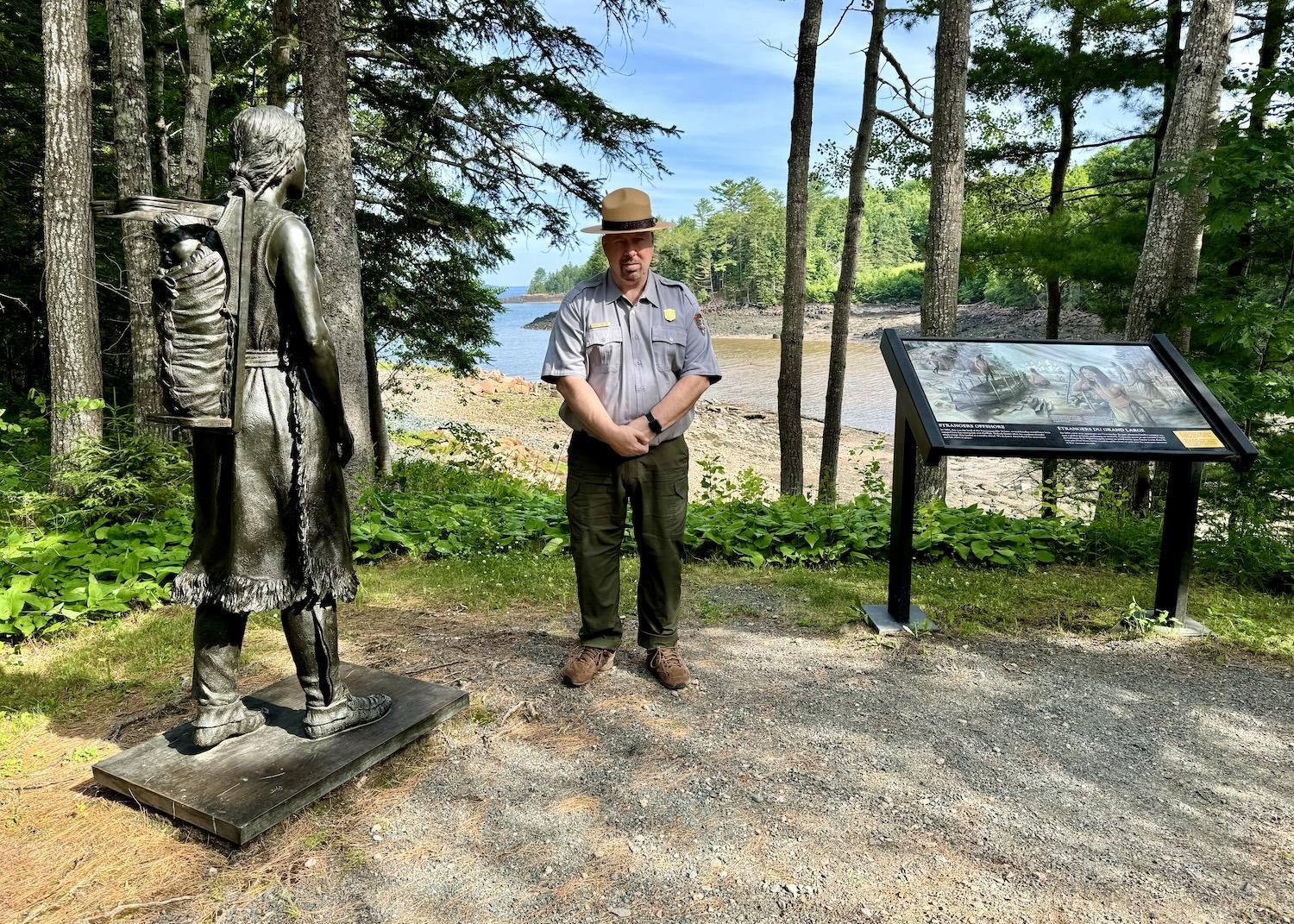 Saint Croix Island site manager Michael Zwelling stands by a bronze speaks to the fact that French colonists landed on the Passamaquoddy homeland.