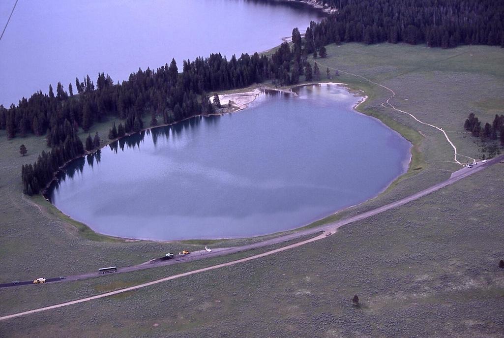 Aerial photo of the 0.06 square mile (0.16 square kilometer) Indian Pond hydrothermal explosion crater north of Yellowstone Lake. The deposits from the explosion that formed the crater were dated with radiocarbon to 2,900 years ago. Photo from Yellowstone